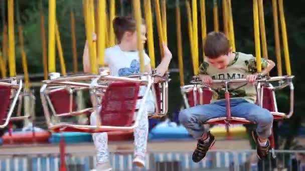Oscilaciones de carrusel con niños en el parque de atracciones — Vídeo de stock