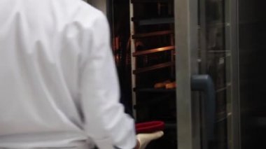 Şef bir tepsi kızarmış balık çeker ve masanın üzerine koyar