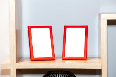 Bookshelf üzerinde iki boş fotoğraf çerçeveleri