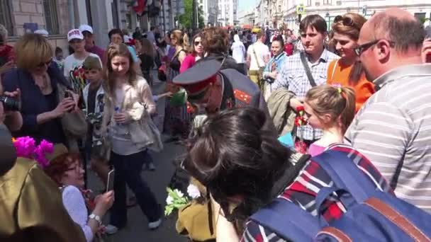 День Победы 9 мая в Москве, Россия. Люди поздравляют ветеранов, дарят цветы — стоковое видео