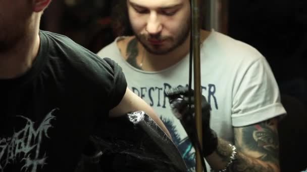 Татуировка на теле. Татуировщик делает татуировку в студии — стоковое видео