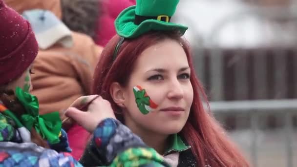 Εορτασμός της ιρλανδικής Αγίου Patricks ημέρα στη Μόσχα, Ρωσία. Ζωγραφική ιρλανδική σημαία στο πρόσωπό κορίτσι. — Αρχείο Βίντεο