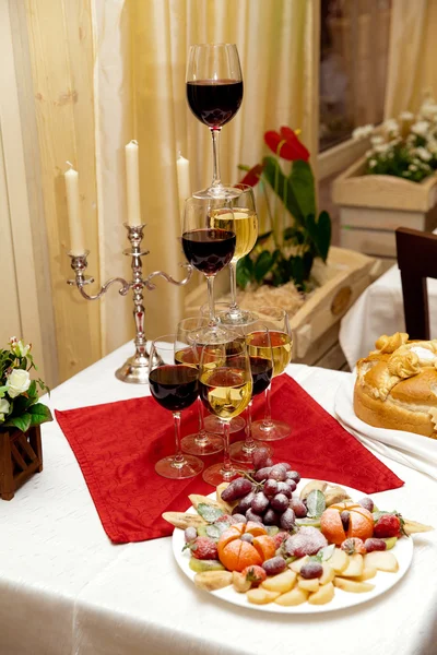 Wine glasses and fruits table — Stock Photo, Image