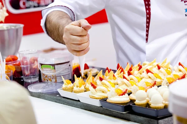 Decorating cupcakes with whipped cream — Stock Photo, Image