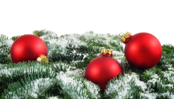 Boules de Noël rouges et neige sur les branches de sapin — Photo