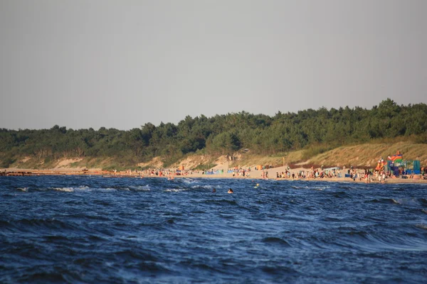 Plaj güneş su hava deniz kum dalgaları insanları tatil sunbather gökyüzü