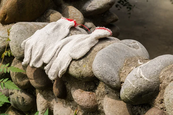 Handskar arbetstagare lämnades på en stenmur. — Stockfoto