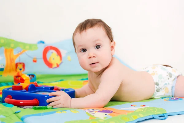 Barnet leker med pedagogiska leksaker liggande — Stockfoto