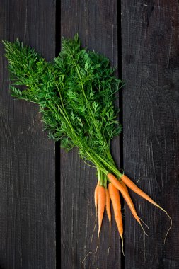 ahşap arka plan üzerinde demet taze havuç yeşil yaprakları