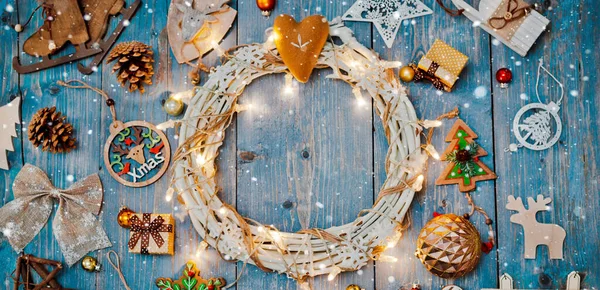 Nowy rok dekoracje wokół świątecznego wieńca na niebieskim drewnianym tle. — Zdjęcie stockowe