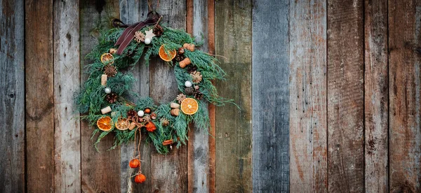 Grüner Weihnachtskranz auf Holz-Hintergrund — Stockfoto