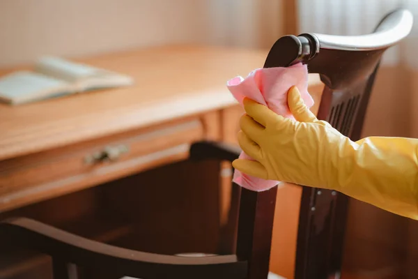 Limpeza e manutenção de mesa de cadeira de móveis de madeira com pano e agente de limpeza — Fotografia de Stock