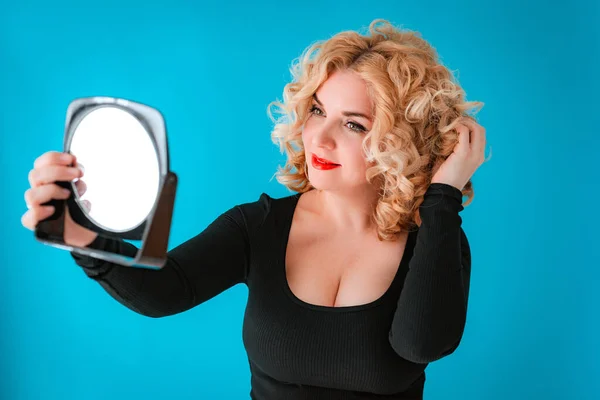 Blonde with retro hair bright red lipstick lips and makeup front mirror. old Hollywood wave look. Portrait beautiful 35-40 year old woman glamorous vulgar image.