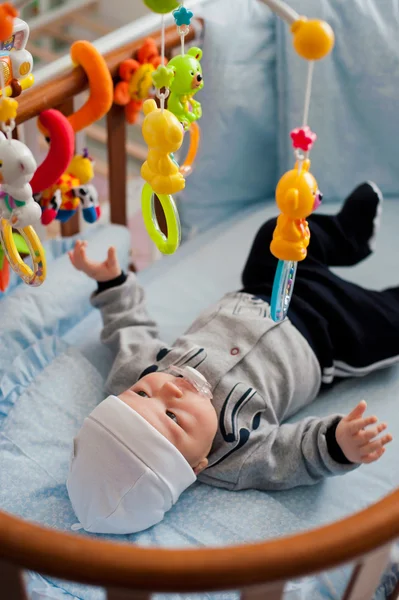 Bebê brincando em um berço — Fotografia de Stock