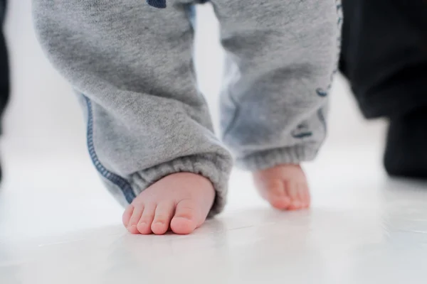 Baby steps with the help of his father — Stock Photo, Image