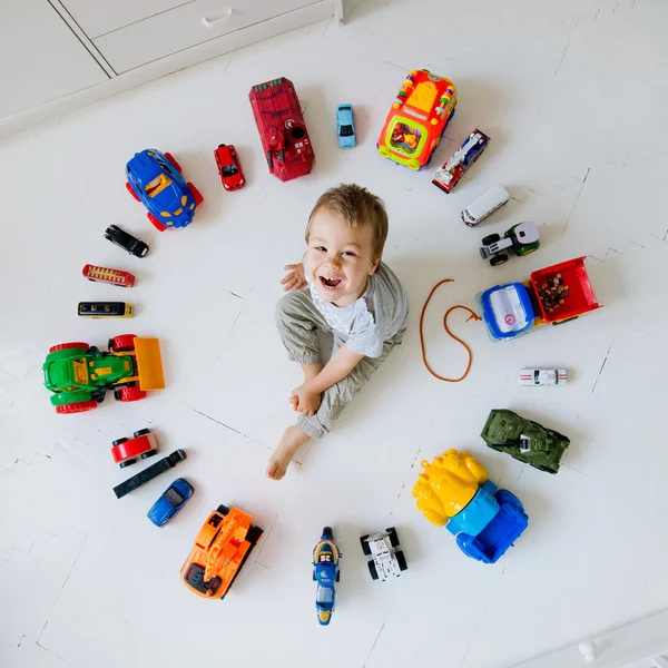 Мальчик с игрушечными машинами — стоковое фото