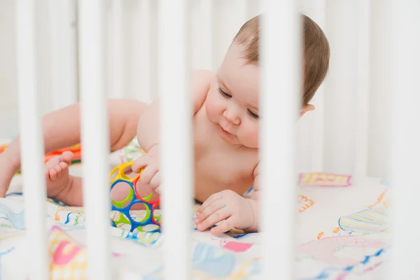 Baby spela i en krubba — Stockfoto