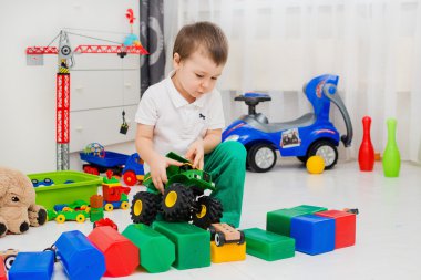 Çocuk arabayla oynuyor.