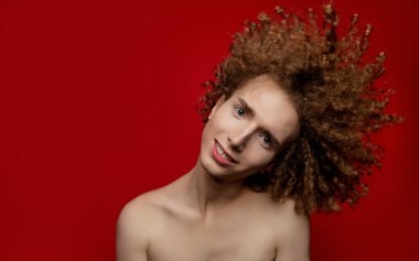 Stüdyoda poz veren kıvırcık saçlı erkek model.