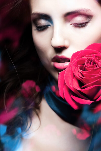 Beautiful woman with red rose and blue lights