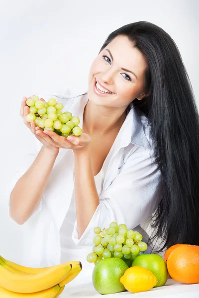 Сексуальная улыбающаяся женщина с виноградом в руках — стоковое фото
