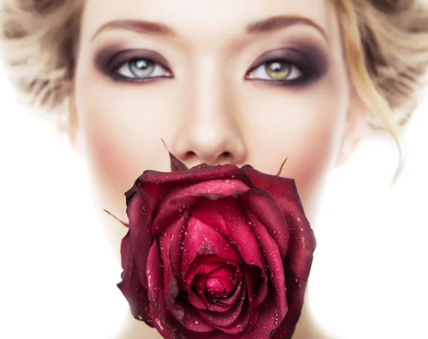 Attraktives Mädchen mit roter Rose im Mund — Stockfoto