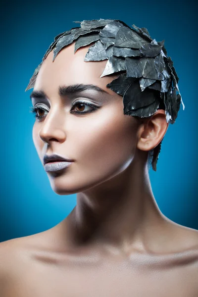 Женщина в шляпе из серебряных листьев — стоковое фото