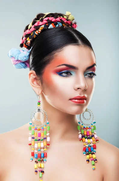 Brunette meisje in lange kleurrijke oorbellen — Stockfoto