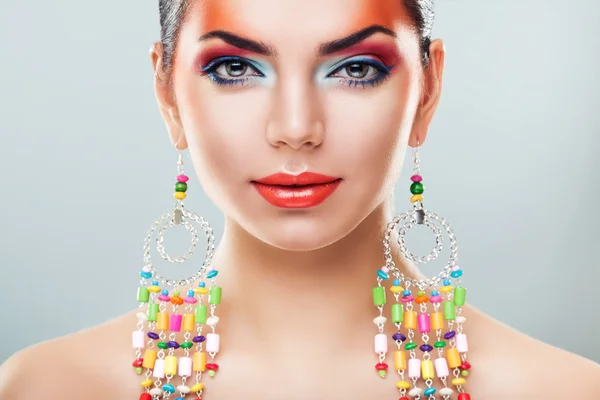 Brunette woman in long colourful earrings — Stock Photo, Image