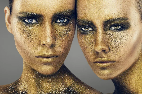 Two pretty women in gold glitters — Stock Photo, Image