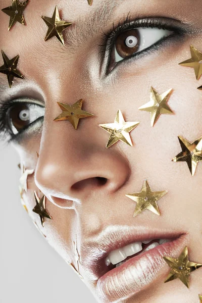 Woman with gold stars on face — Stock Photo, Image