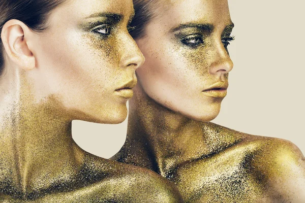 Две красивые женщины в золотом блеске — стоковое фото