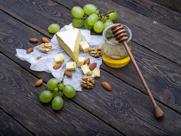 Cheese with grapes, honey and nuts — Stock Photo, Image