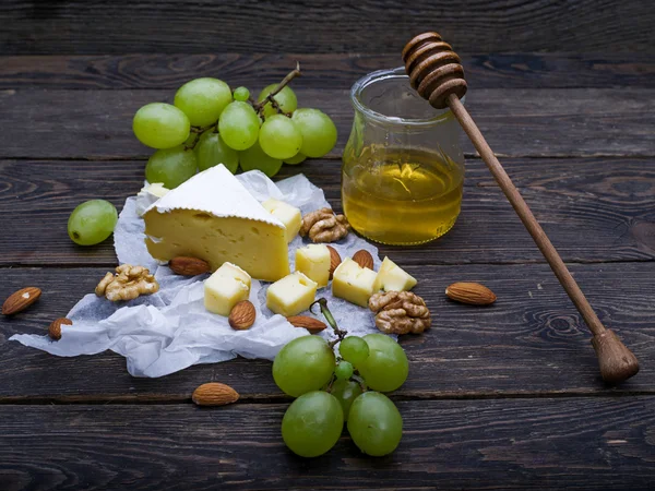 Cheese with grapes, honey and nuts — Stock Photo, Image