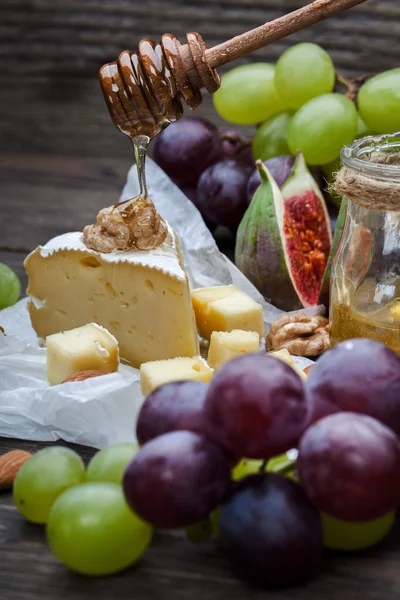 Cheese with grapes, honey and nuts — Stock Photo, Image