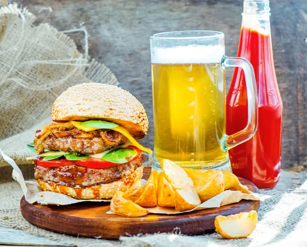 Hamburger kızarmış patates, bira ve sos ile — Stok fotoğraf