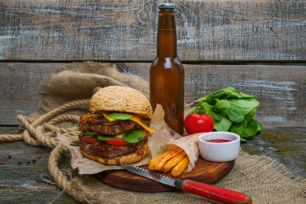 Гамбургер с жареной картошкой, пивом и соусом — стоковое фото