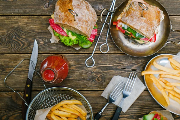 Sanduíches com legumes, batatas fritas e molho — Fotografia de Stock