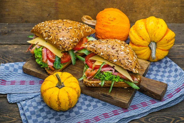 Hamburgers with fresh vegetables and small pumpkins — Stock Photo, Image