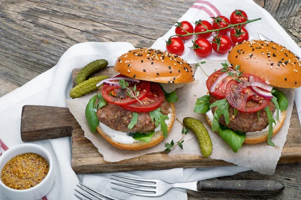 Hamburgers with beef patties and salad ingredients — Stock Photo, Image