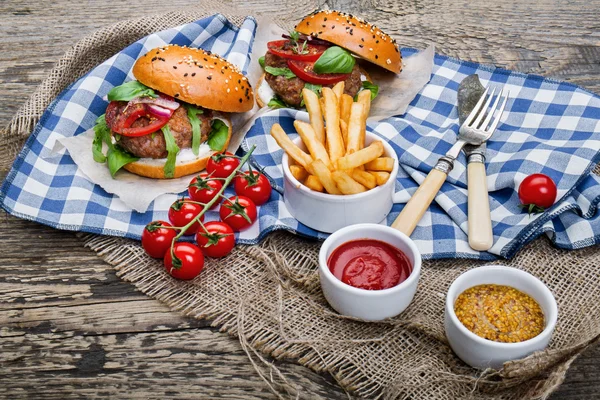 Hamburgers with beef patties and salad ingredients — Stock Photo, Image