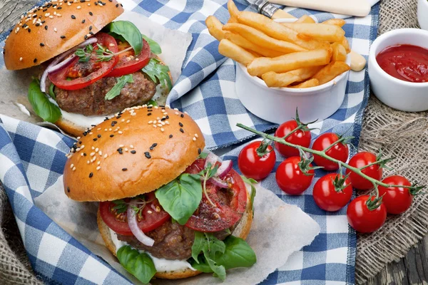 Hamburgers with beef patties and salad ingredients — Stock Photo, Image