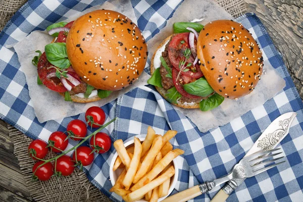 Hamburgers with beef patties and salad ingredients — Stock Photo, Image