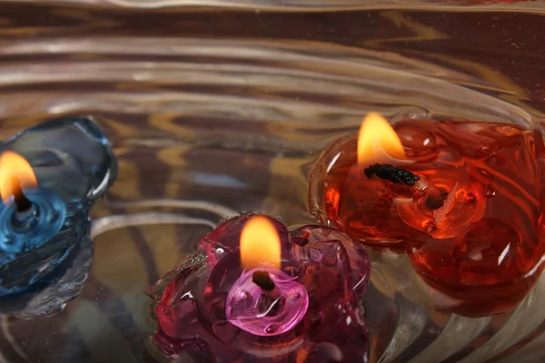 Три восковые свечи на воде — стоковое фото