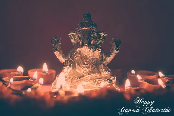 Ganesh idol surrounding with oil lamp, festival season, retro ef — Stock Photo, Image