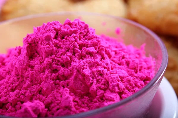 Holi-Farbe in Schüssel mit verschwommenen Gujiya-Snacks — Stockfoto