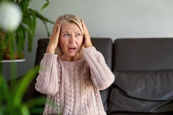 Frau leidet unter Kopfschmerzen und Stress, wenn sie ihre Hände an die Schläfen hält — Stockfoto