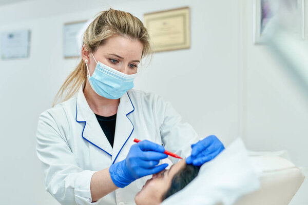 Концепция пластической хирургии, врачи вручают перчатки, оставляя отметины на лице пациента