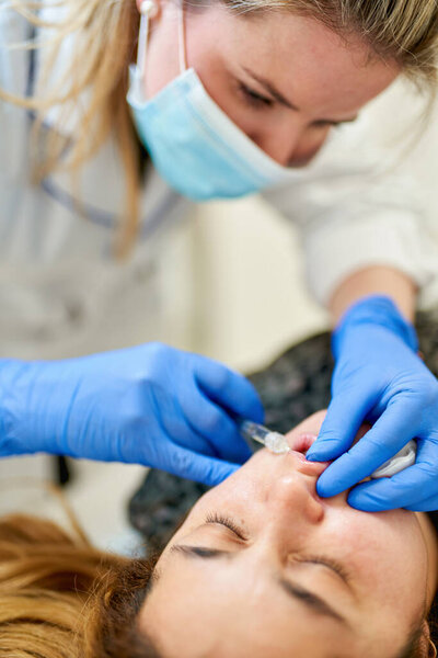 Lip Augmentation. Woman Getting Beauty Injection For Lips.The doctor cosmetologist makes Lip augmentation procedure of a beautiful woman in a beauty salon.