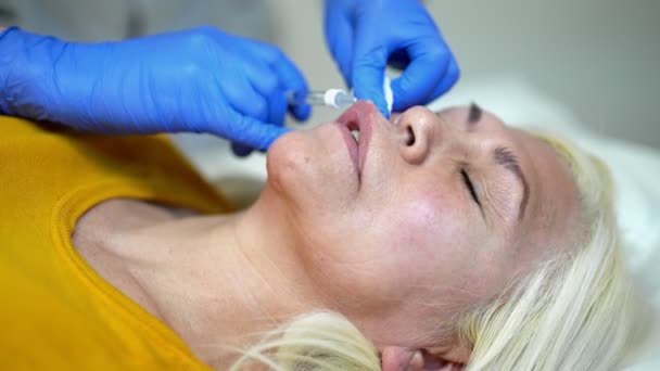 Nahaufnahme der Hände eines Kosmetikers, der Botox injiziert. Sie hält eine Spritze. Frau erhält Verfahren mit Genuss — Stockvideo